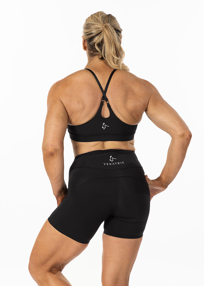 
                  
                    Back view of a black padded sports bra with adjustable straps and a supportive design for running.
                  
                